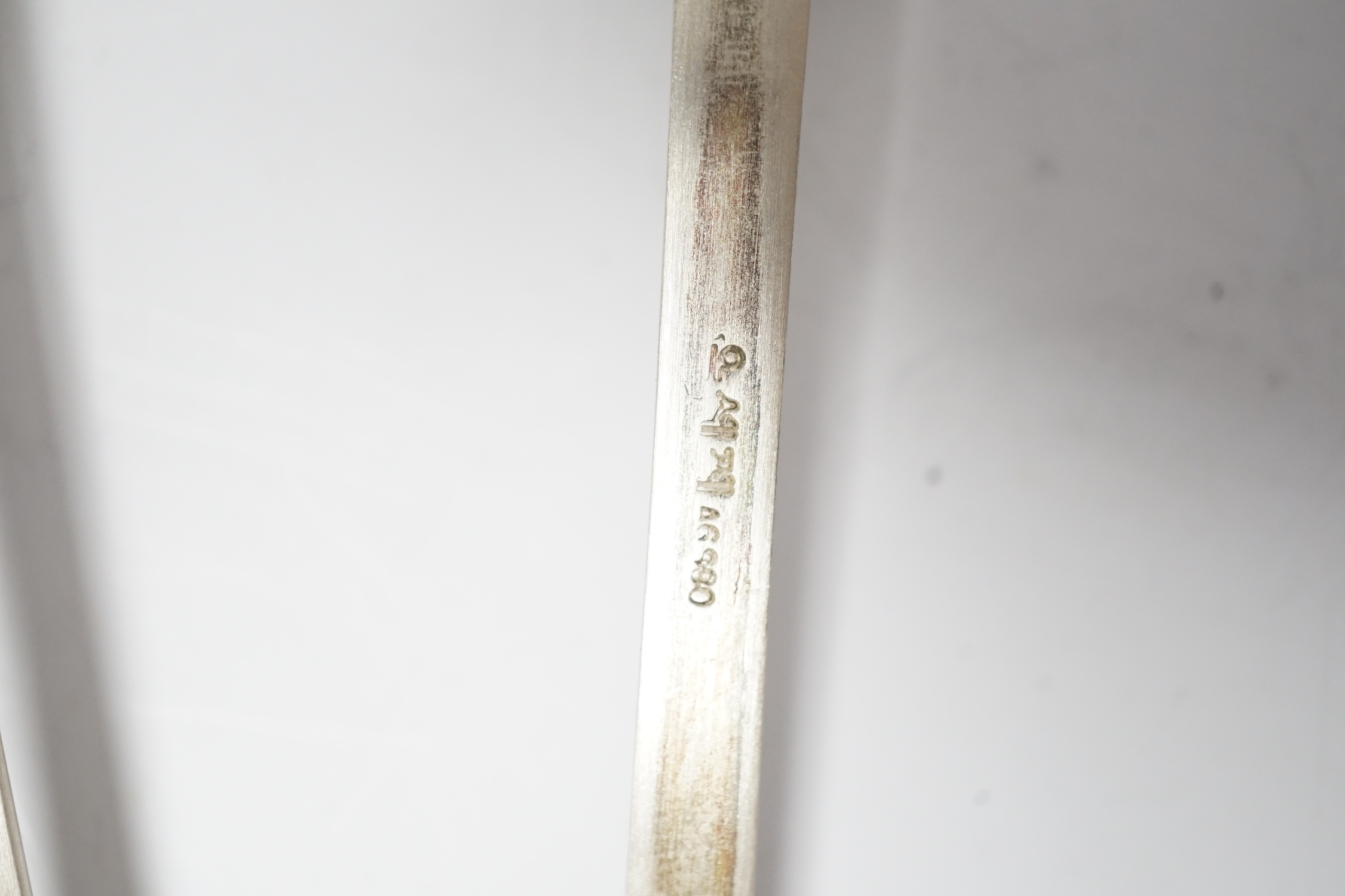 A Korean 990 standard white metal pair of chopsticks, 20cm and two matching spoons with enamelled decoration.
